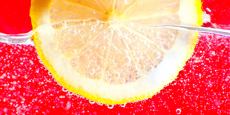 Un bicchiere di acqua frizzante con una fetta di limone